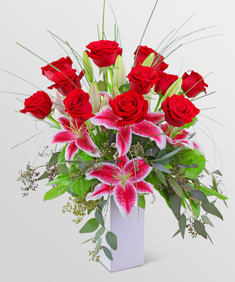 12 long stem roses acomppanied by pink lilies and greenery